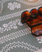 A close-up of a scalloped tortoiseshell mahjong rack on a green floral serpentine leatherette mahjong mat.