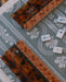 A close-up overhead view of a mahjong table setup with two 20' tortoiseshell scalloped mahjong racks on a green floral serpentine leatherette mahjong mat with mahjong tiles.